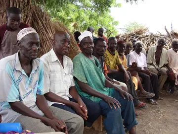 Community members seated together during a village meeting near Tamale