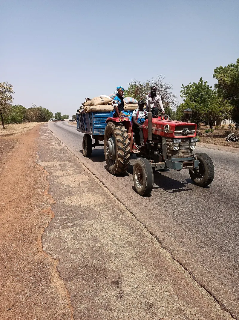 A tractor carrying sacks of farm produce on a road in Northern Ghana